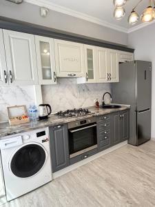 a kitchen with a washing machine and a refrigerator at Boulevard terrace apartment in Chişinău +16 photos