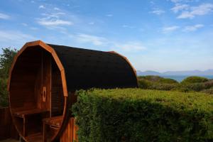 a wooden shed with a black roof in a hedge at Southerlys Beach House in Dolphin Sands +53 photos