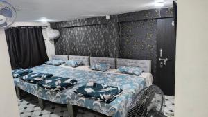 a bedroom with a bed with blue sheets and blue pillows at Modern Guest House in Ujjain