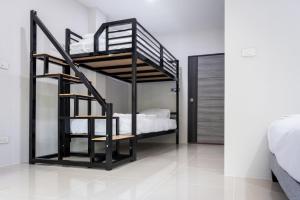 a black bunk bed in a white room with a bedroom at Dana Residence in Ko Yao Noi