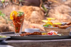 a table with a plate of food and a drink at Villas Isla Montosa in Coyuca de Benítez