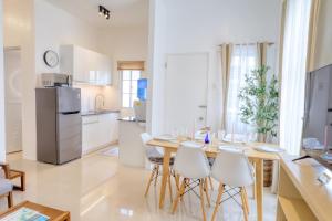 a kitchen and dining room with a wooden table and chairs at 3BR Guesthouse near Panglao - Pool Access - Bohol Tours - Fast WiFi in Dauis