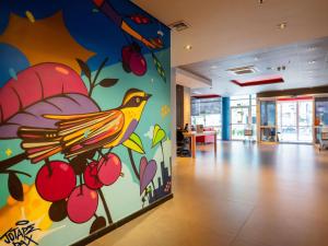 a wall with a painting of a bird on it at ibis budget Porto Alegre - Super Econômico in Porto Alegre +77 photos