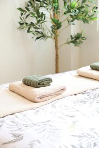 two towels on a bed with a tree in the background at 3BR Guesthouse near Panglao - Pool Access - Bohol Tours - Fast WiFi in Dauis +66 photos