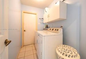 a small white laundry room with a washer at Across from Sawgrass Mall- Next to Amerant Bank Arena in Sunrise +20 photos