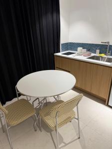 a white table and two chairs in a kitchen at 제주 디스피어 호텔 D-Sphere in Jeju +112 photos