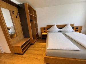 a bedroom with a bed and a large mirror at Gästehaus Jedinger - Easy Lake Access by Tram in Sankt Georgen im Attergau
