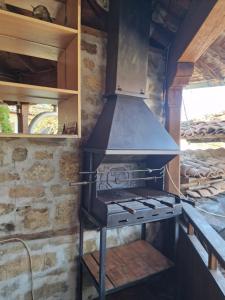 a stove in a room with a stone wall at Престиж in Arbanasi