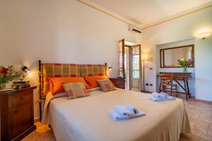a bedroom with a large white bed with towels on it at Agriturismo Il Cavallino Saturnia in Semproniano +153 photos