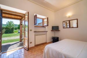 a bedroom with a bed and a sliding glass door at Agriturismo Il Cavallino Saturnia in Semproniano