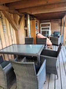 a glass table and chairs on a deck at Franks kleines Bauernhaus in Dresden in Dresden