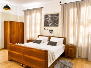 a bedroom with a large wooden bed with white sheets at Rezidenca Korman in Fala