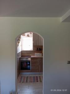 an archway in a kitchen with a stove and a window at WallerKarpfenBosnien in Šiljkovača +23 photos