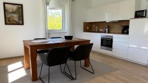 a kitchen with a wooden table and two chairs at Wohlfühlapartments Steiner in Altmünster +10 photos