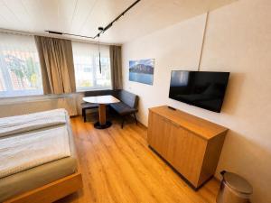 a room with a bed and a television on a wall at Gästehaus Jedinger - Easy Lake Access by Tram in Sankt Georgen im Attergau