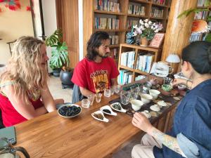 a group of people sitting around a wooden table at October Inn in Lijiang +88 photos
