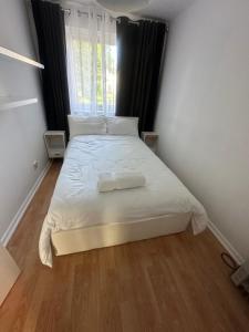 a bedroom with a bed with white sheets and a window at Charming Flat in North London in Edmonton +6 photos