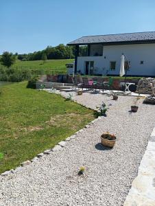 a house with a patio and a yard with a yard at WallerKarpfenBosnien in Šiljkovača