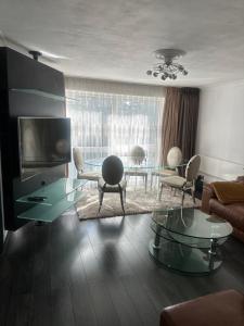 a living room with a couch and a glass table at Charming Flat in North London in Edmonton