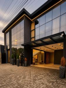 a house with large glass windows and potted plants at Hotel El Shaddai in Pontes e Lacerda