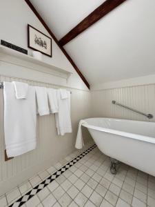 a bathroom with a large white tub and towels at Windsor House Inn in Saint Andrews