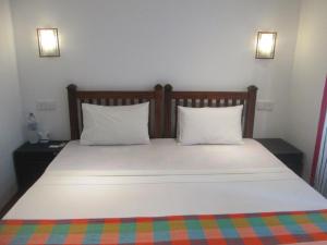 una camera da letto con un grande letto con due cuscini di Bay Reach Home Stay a Weligama