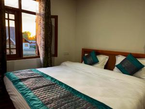 a bedroom with a large bed with a window at The Other House Srinagar in Srinagar +11 photos