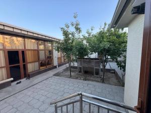 an empty courtyard with trees in front of a building at Dada guest house in Bukhara
