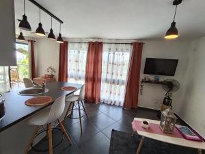 a kitchen and living room with a table and chairs at Résidence Amarosa in Les Avirons