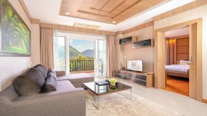 a living room with a couch and a window with a bed at Lacol Khao Yai - A Chatrium Collection in Mu Si
