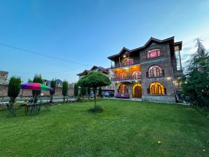 a large house with a lawn in front of it at The Other House Srinagar in Srinagar
