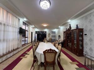 a long dining room with a long table and chairs at Dada guest house in Bukhara
