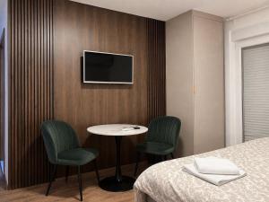 a hotel room with a bed and a table and chairs at Tomm in Trebinje