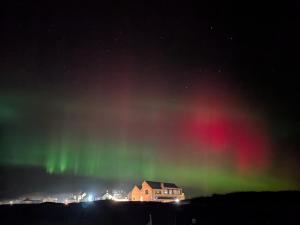 an aurora in the sky over a house at Chameleon House in Dornoch