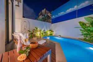a living room with a pool and a table with a drink at 2BR villa w- pool & beach access in Mengwi