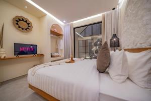 a bedroom with a large white bed and a window at 2BR villa w- pool & beach access in Mengwi +184 photos