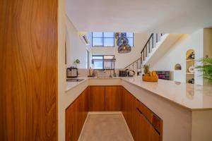 a kitchen with wooden cabinets and a staircase at 2BR villa w- pool & beach access in Mengwi