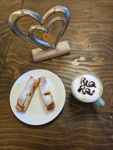 a plate with a piece of cake and a cup of coffee at B&B Rio Rai Alpe Adria in Gemona del Friuli