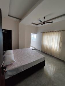 a bedroom with a bed and a ceiling fan at Heaven Heights in Rājpur