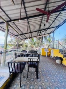 a restaurant with tables and chairs on a balcony at Calangute house inn in Calangute
