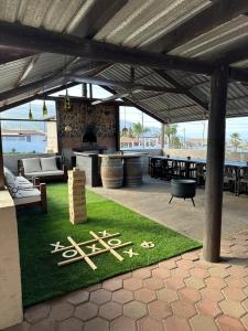 acovered patio with a table and a sign on the grass at Casa Isabel in Ensenada
