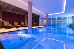 - une grande piscine avec des chaises dans un bâtiment dans l'établissement Alpenhotel Ischglerhof, à Ischgl