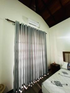 a bedroom with a bed and a window with curtains at Lanthana Villa Kandy in Kandy +36 photos