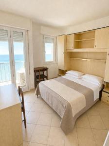 a bedroom with a bed and a view of the ocean at President Frontemare - Agenzia Cocal in Caorle