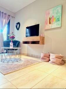 a living room with a table and a tv at Petit Charlie @ Forest view in Banjul