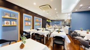 a dining room with white tables and black chairs at Grand Park Hotel Panex Tokyo in Tokyo