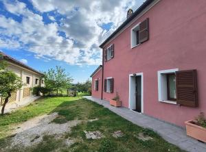 a pink house on the side of a street at Casa Rosa in San Costanzo