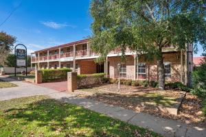 a brick building with a tree in front of it at Quality Inn Colonial in Bendigo