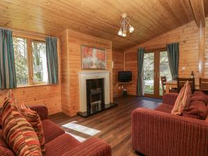 a living room with two couches and a fireplace at Elm Lodge in Keswick