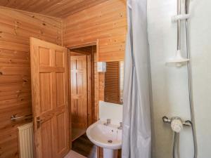 a bathroom with a sink and a toilet and a shower at Elm Lodge in Keswick +79 photos